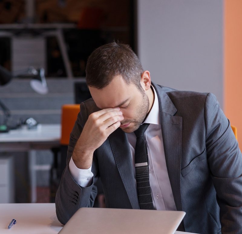 frustrated young business man working on laptop computer at office